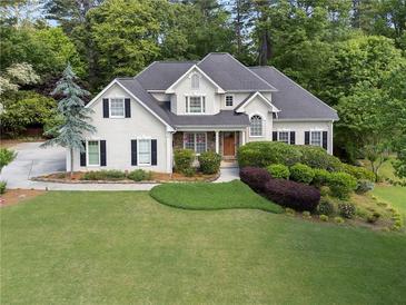 Charming two-story home boasts a lush green lawn and meticulously manicured landscaping at 1605 Little Lisa Ln, Snellville, GA 30078