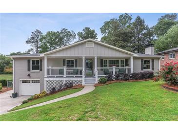 Charming brick home with a welcoming front porch, beautiful landscaping, and an attached single car garage at 185 Pamela Nw St, Marietta, GA 30064