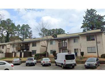 Exterior view of a multi-unit residential building featuring balconies and ample parking at 3796 Kensingwood Trce, Decatur, GA 30032
