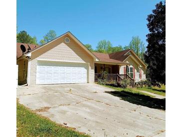 Charming single-story home with an attached two-car garage and a quaint front porch at 6690 Jenkins Rd, Fairburn, GA 30213