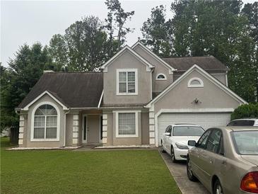 Charming two-story home featuring a well-manicured lawn, neutral stucco, and an attached two-car garage at 3393 Chancellors Dr, Powder Springs, GA 30127