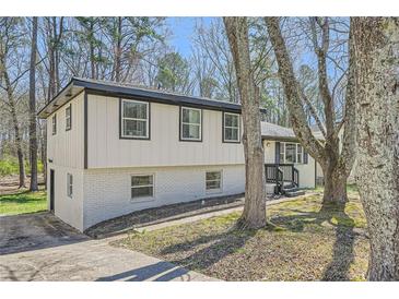 Charming home with brick and siding and large trees in the front yard at 6552 King George Way, Morrow, GA 30260