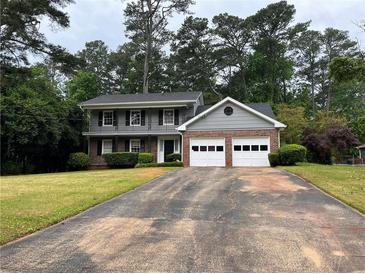 Charming two-story home with a two-car garage and a well-maintained front yard, nestled among mature trees at 765 Corundum Ct, Stone Mountain, GA 30083