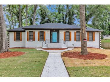 Charming painted brick home featuring a blue front door and shuttered windows at 4576 Dorset Circle, Decatur, GA 30035