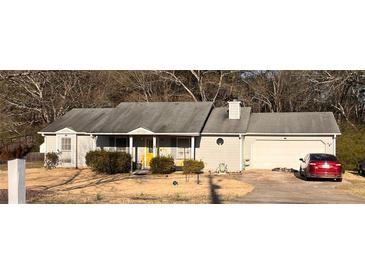 Charming single-story home featuring a well-maintained lawn and attached two car garage at 497 Natasha Dr, Auburn, GA 30011