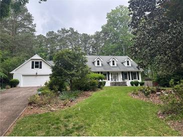 Charming home with a lush front lawn and attached garage, surrounded by mature trees at 3 Perthshire Dr, Peachtree City, GA 30269