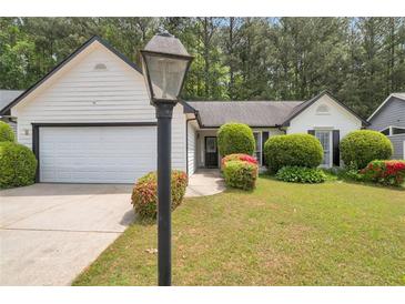 Charming one-story home with a manicured lawn, mature shrubs, and two-car garage at 3130 Jorden Crest Ct, Lawrenceville, GA 30044