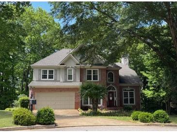 Charming two-story brick home with mature trees and a well-manicured lawn at 4055 Vista Point Ln, Suwanee, GA 30024
