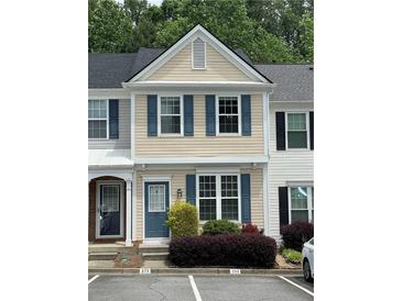 Charming townhome with blue shutters and manicured landscaping for a cozy curb appeal at 211 Buckland Dr, Alpharetta, GA 30022