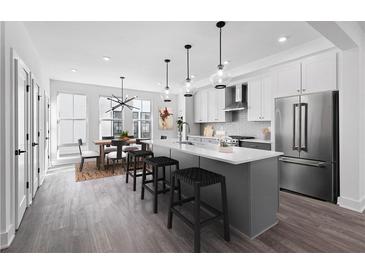 Bright kitchen features stainless steel appliances, a large island with barstool seating, and an adjacent dining area at 507 Motivation Nw Cir, Atlanta, GA 30309
