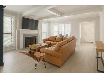 Bright living room featuring a fireplace, hardwood floors, and a comfortable brown leather sofa at 802 Lismore Se # 2, Smyrna, GA 30080