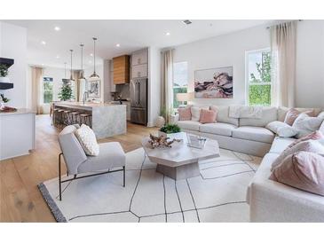 Bright open concept living room featuring modern decor, hardwood floors, and seamless flow into the kitchen at 515 Motivation Nw Cir, Atlanta, GA 30309