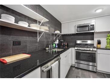 Modern kitchen features stainless steel appliances, dark countertops, and white cabinets at 1501 Clairmont Rd # 1522, Decatur, GA 30033