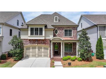 Charming brick home with manicured lawn, inviting front porch, and attached two-car garage at 919 Olmsted Ln, Johns Creek, GA 30097