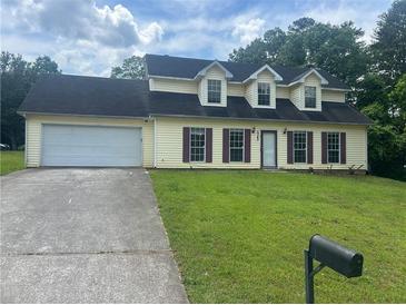 Charming two-story home with a well-maintained lawn, attached garage and long driveway at 5340 Forest Pl, Stone Mountain, GA 30088