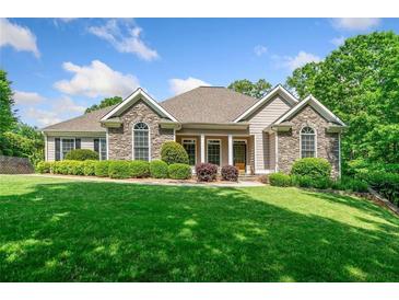 Beautiful stone and siding home with mature landscaping, green lawn, and a welcoming facade at 132 Copper Hills Dr, Canton, GA 30114