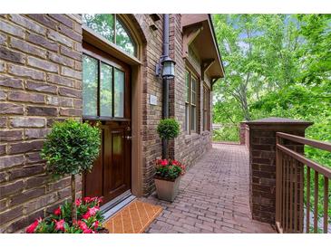 Charming brick home featuring a wood front door, brick pathway, and lovely landscaping at 1832 Gordon Ne Mnr, Atlanta, GA 30307