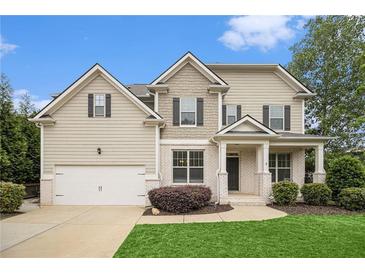 Charming two-story home featuring manicured lawn, a two-car garage, and classic architectural details at 308 Evening Rain Crst, Canton, GA 30114