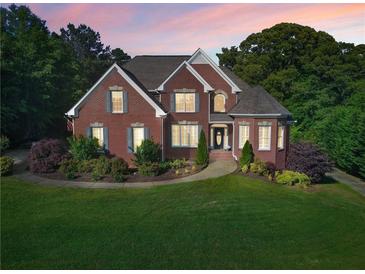Charming brick home with a well-manicured lawn and beautiful landscaping at 5360 Franklin Goldmine Rd, Cumming, GA 30028