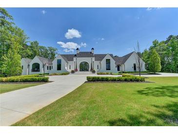 Elegant white brick home with manicured lawn and long driveway leading to the grand entrance at 2305 Braselton Hwy, Buford, GA 30519