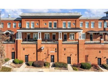 Multi-level red brick building with multiple balconies and private entrances at 3930 Charleston Market St # 221, Suwanee, GA 30024