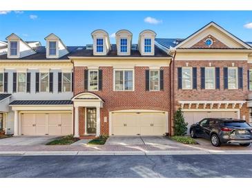 Charming brick townhome featuring dormer windows and attached two-car garage at 2260 Edgartown Se Ln # 1, Smyrna, GA 30080