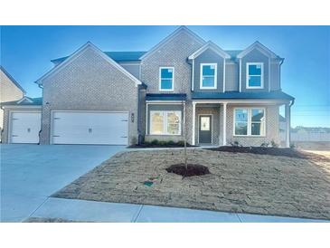 Charming two-story home with gray brick, a two-car garage, manicured lawn and covered entryway at 98 Longhorn Way, Auburn, GA 30011