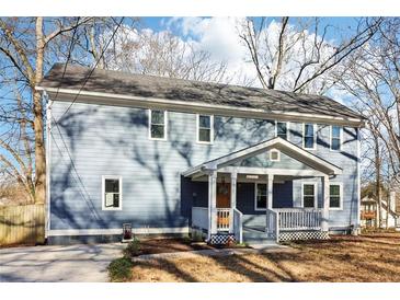 Charming two-story home with a welcoming front porch and blue siding, nestled among mature trees at 1977 Nash Se Ave, Atlanta, GA 30316