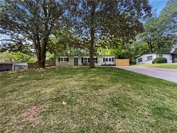 Charming single-story home featuring mature trees and a well-manicured lawn at 4239 Canby Ln, Decatur, GA 30035