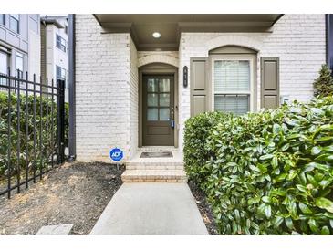 Inviting townhome entrance with brick facade, arched entryway, and verdant landscaping at 635 Broadview Ne Pl, Atlanta, GA 30324