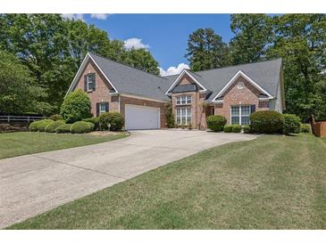 Charming brick home featuring a well-manicured lawn and an extended driveway at 1561 Oak Ivy Ln, Lawrenceville, GA 30043