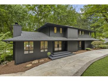 Striking contemporary two-story home featuring a dark exterior and lush surroundings at 1860 Mountain Shadow, Stone Mountain, GA 30087