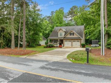 Charming two-story home featuring a covered porch, attached two-car garage, and a well-manicured front yard at 4079 Essex Dr, Villa Rica, GA 30180