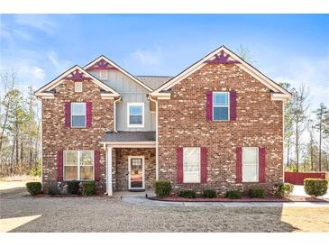 Charming two-story brick home with a well-maintained lawn and complementary trim at 12348 Hillcrest Dr, Hampton, GA 30228