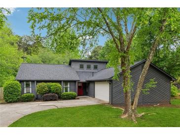 Charming home featuring a gray exterior, manicured landscaping, and a welcoming red front door at 1280 Gin House Ln, Lawrenceville, GA 30045
