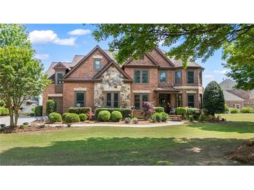 Beautiful brick home featuring manicured landscaping and stone accents on the facade at 2400 Gants Hill Pl, Cumming, GA 30041