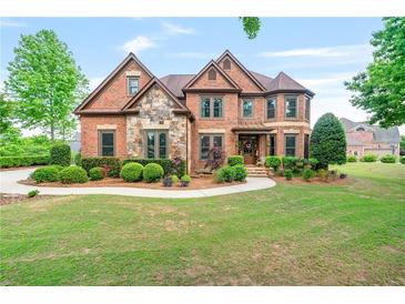 Beautiful two-story brick home with manicured lawn and stone accents at 2400 Gants Hill Pl, Cumming, GA 30041
