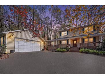 Charming two-story home featuring a welcoming front porch, a spacious driveway and attached garage at 4211 Burnt Hickory Nw Rd, Marietta, GA 30064