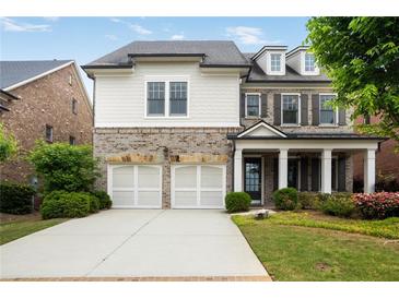 Charming two-story home featuring a brick and siding facade, a two-car garage, and a well-manicured front lawn at 4884 Kentwood Dr, Marietta, GA 30068