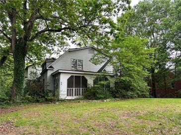 Quaint two-story home exterior featuring a screened-in porch and mature trees at 2413 Charleston Oaks Ln, Decatur, GA 30030