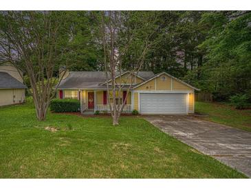 Charming single-Gathering home with yellow siding, red shutters, well-maintained lawn, and attached garage at 2631 Rolling Hills Way, Conyers, GA 30094