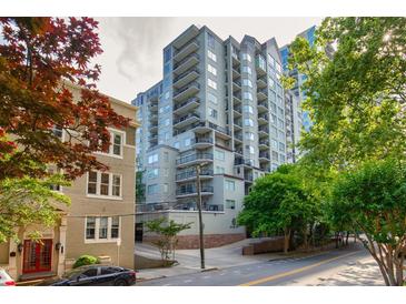 A modern condominium building with multiple balconies and large windows is surrounded by lush green trees at 275 13Th Ne St # 409, Atlanta, GA 30309