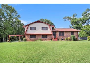 Charming two-story home with a brick facade, large front yard, and a convenient carport at 3510 Spring Valley Blvd, Atlanta, GA 30349
