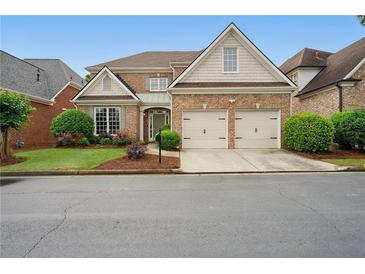 Charming brick home featuring a two-car garage, manicured lawn, and inviting landscaping in a desirable neighborhood at 6355 Glen Oaks Ln, Atlanta, GA 30328