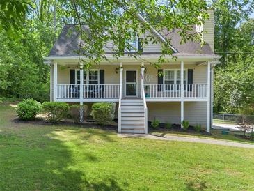 Charming home with a welcoming front porch, manicured lawn, and mature trees enhancing curb appeal at 411 Hollis Cir, Dallas, GA 30157