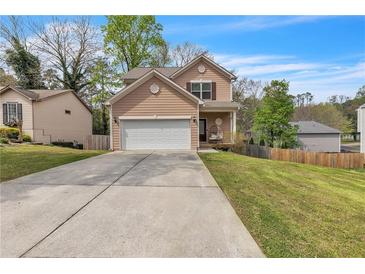 Charming two-story home featuring a two-car garage, well-manicured lawn, and inviting front porch at 4567 Hickory Forest Nw Dr, Acworth, GA 30102