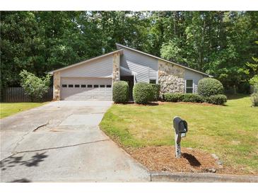 Charming single-Gathering home featuring stone accents, a two-car garage, and lush landscaping at 525 Forest Pl, Roswell, GA 30076
