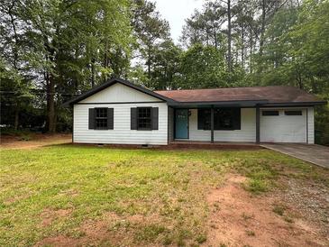 Charming single-story home with a well-maintained lawn and mature trees at 595 Crowell Rd, Porterdale, GA 30014