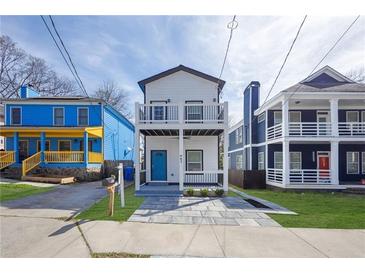 Charming two-story home featuring dual balconies and a vibrant turquoise-colored front door at 962 Welch Sw St, Atlanta, GA 30310