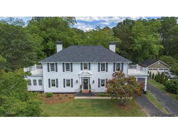 Charming two-story home featuring a lovely front yard, inviting entrance, and convenient carport and separate garage at 6104 Floyd St, Covington, GA 30014